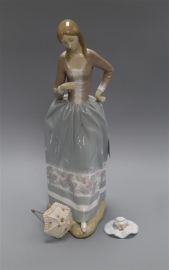 A Lladro figure of a lady with a parasol and a hat height 42cm